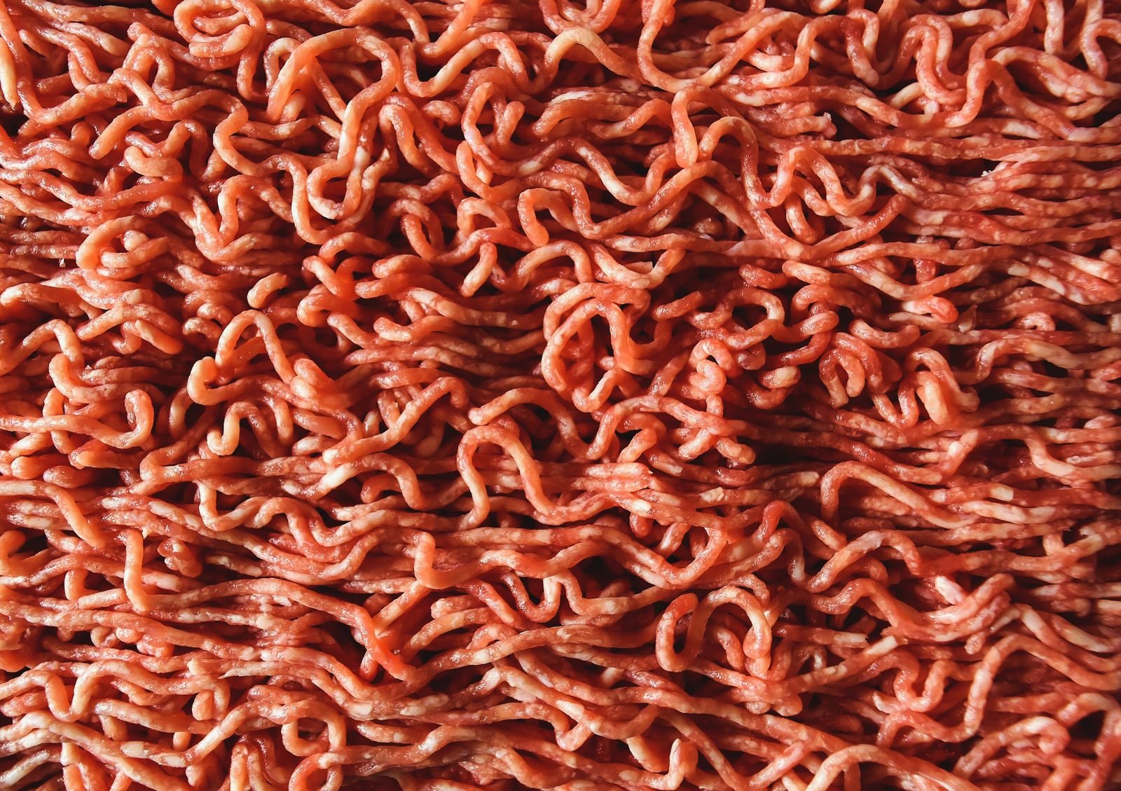 Extreme close-up of fresh strands of ground beef.