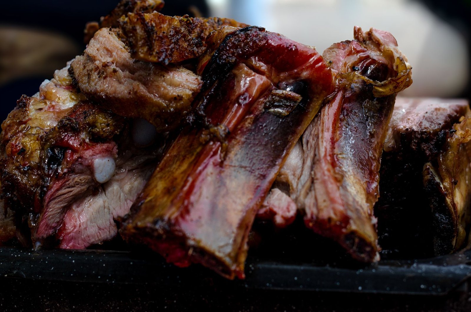 Close-up of grilled beef ribs with charred edges and exposed bones.